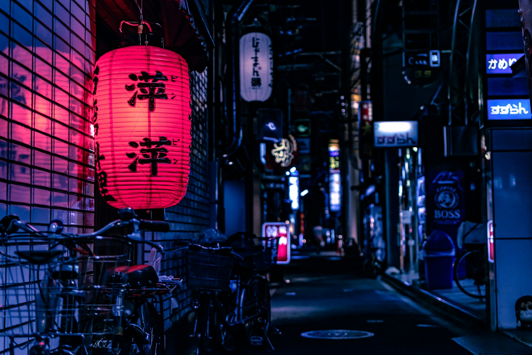 A pink paper lantern glowing in a neon back-alley