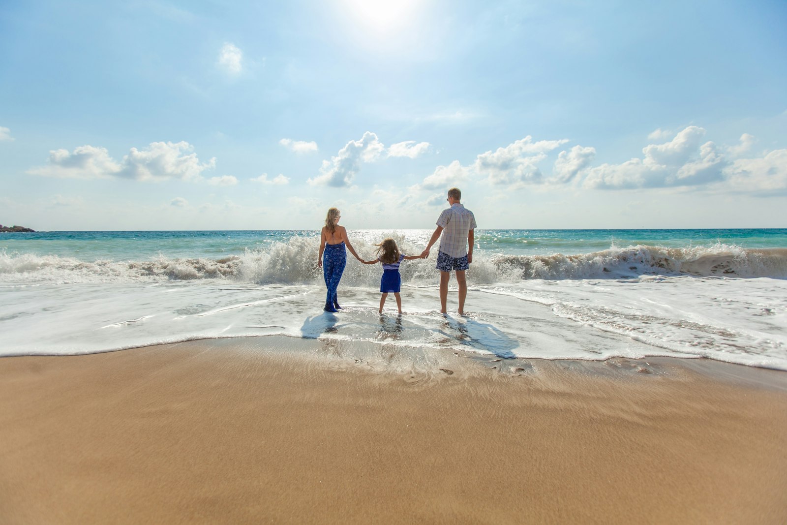 A family standing together in the surf