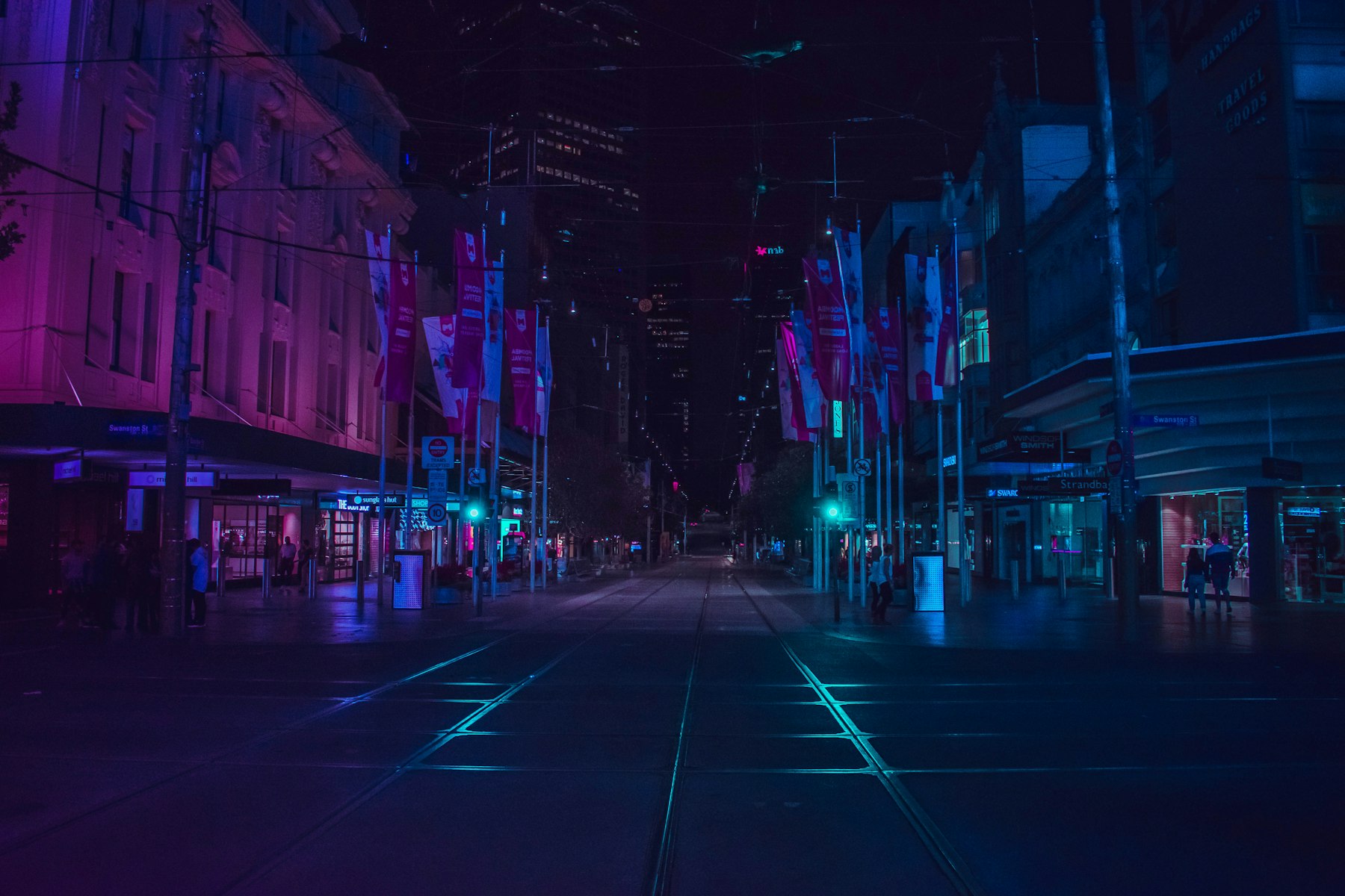 A neon-lit street at night, shown blurred as a myopic eye would see it